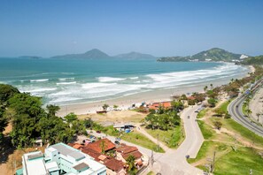 A coastal town with a beach, roads, and buildings. - VELINN Pousada Entre Praias (Ubatuba)