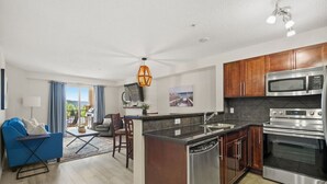 A modern kitchen with dark wood cabinets, stainless steel appliances, and a central island.