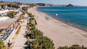 A beachside hotel with a long corridor leading to the beach, outdoor seating, and a view of the sea. - Seafront apartment in the bay of Kefalos, Kos (Kefalos)