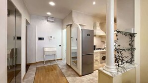 A modern kitchen with a built-in refrigerator, a white countertop, and a marble backsplash. - Center Apartment - Affitti Brevi Italia (Lecco)
