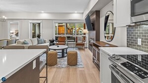 A modern kitchen with a built-in microwave, a stove, and a large window overlooking a deck area. - 3 bed/2 bath Sparrowhawk Resort-Topfloor-Sleeps 8 (Dead Man's Flats)