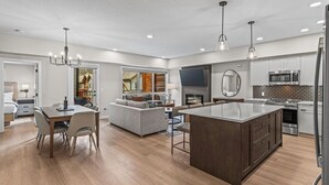 A modern kitchen with a central island, built-in appliances, and a dining area with a sofa and chairs. - 3 bed/2 bath Sparrowhawk Resort-Topfloor-Sleeps 8 (Dead Man's Flats)