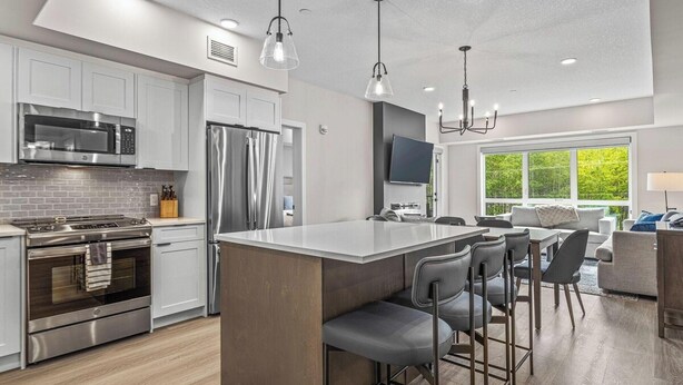 A modern kitchen with stainless steel appliances, a large island, and bar stools. - 2 Bed/2 Bath Sparrowhawk Resort-Sleeps 6 (Dead Man's Flats)