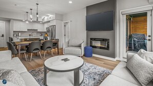 A modern living room with a fireplace, a dining area, and a kitchen in the background. - 2 Bed/2 Bath Sparrowhawk Resort-Sleeps 6 (Dead Man's Flats)