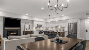 A modern kitchen with a dining area, built-in appliances, and a fireplace.