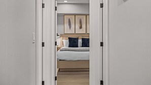 A bedroom with a bed, bedside tables, and framed artwork on the wall.