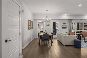 Un interior moderno con zona de comedor, sofá y vista a través de un ventanal.