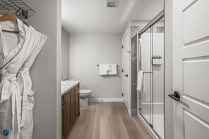Une salle de bain moderne équipée de toilettes, d’un lavabo et d’une douche à parois de verre.