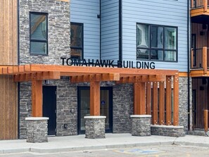 Un bâtiment appelé TOMHAWK BUILDING, doté d’une façade en pierre et de détails en bois.