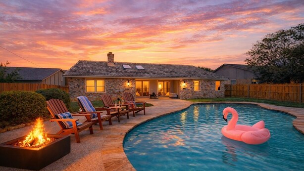 Une maison avec une piscine, un espace salon extérieur et un foyer.