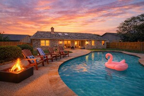 A house with a swimming pool, outdoor seating, and a fire pit.