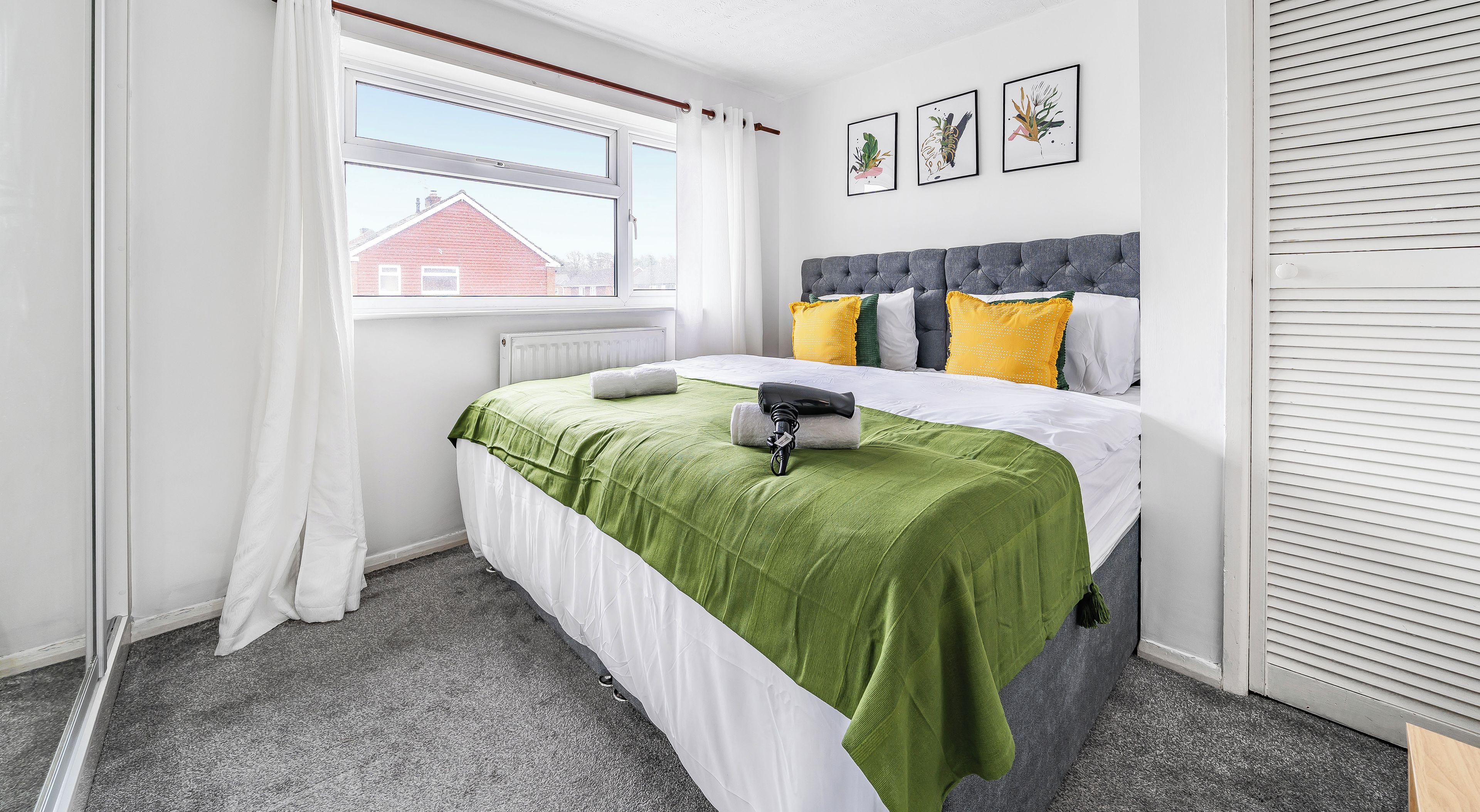 A bedroom with a bed, a window, a radiator, and a door.