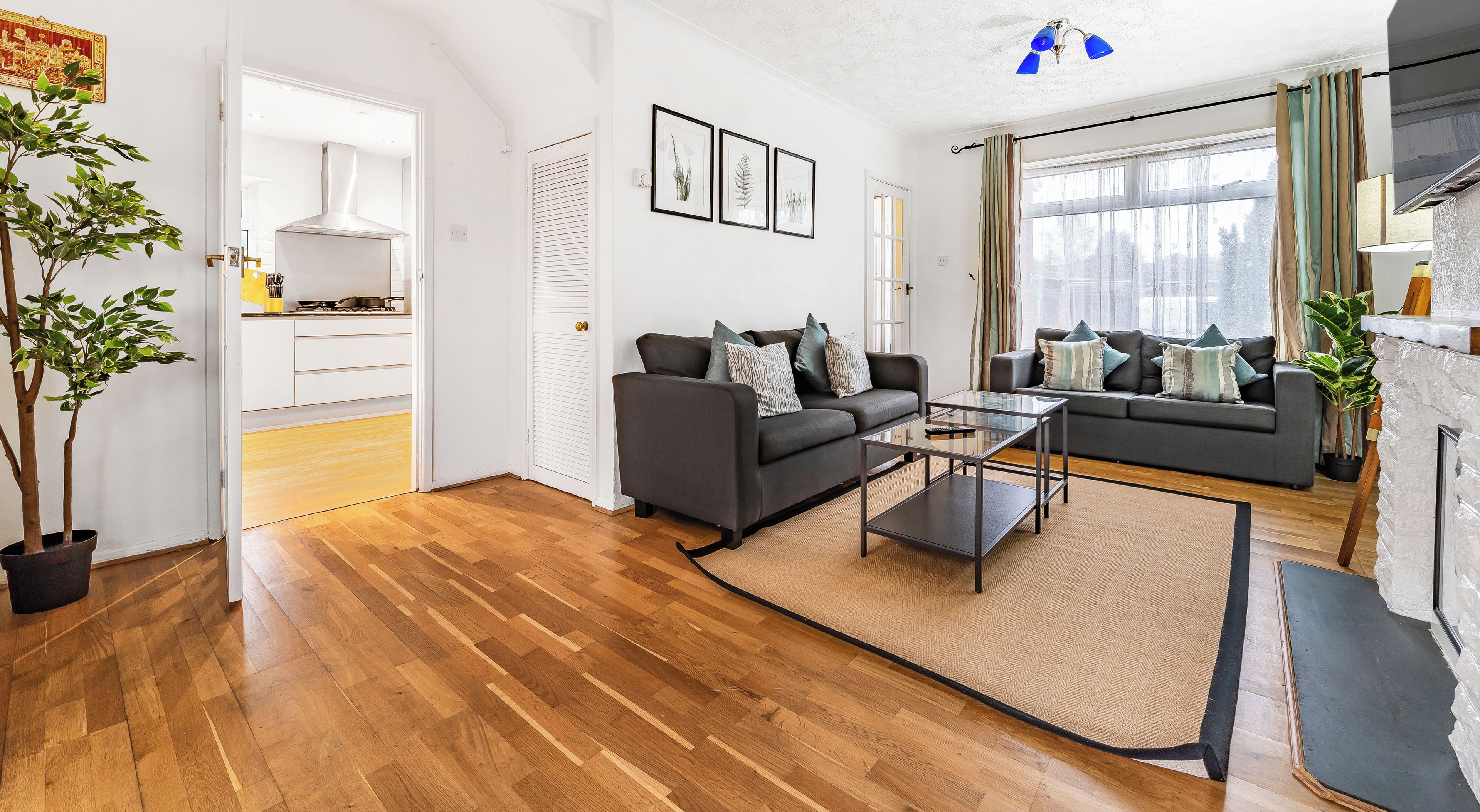 A modern living room with hardwood flooring, two sofas, a coffee table, and a fireplace.