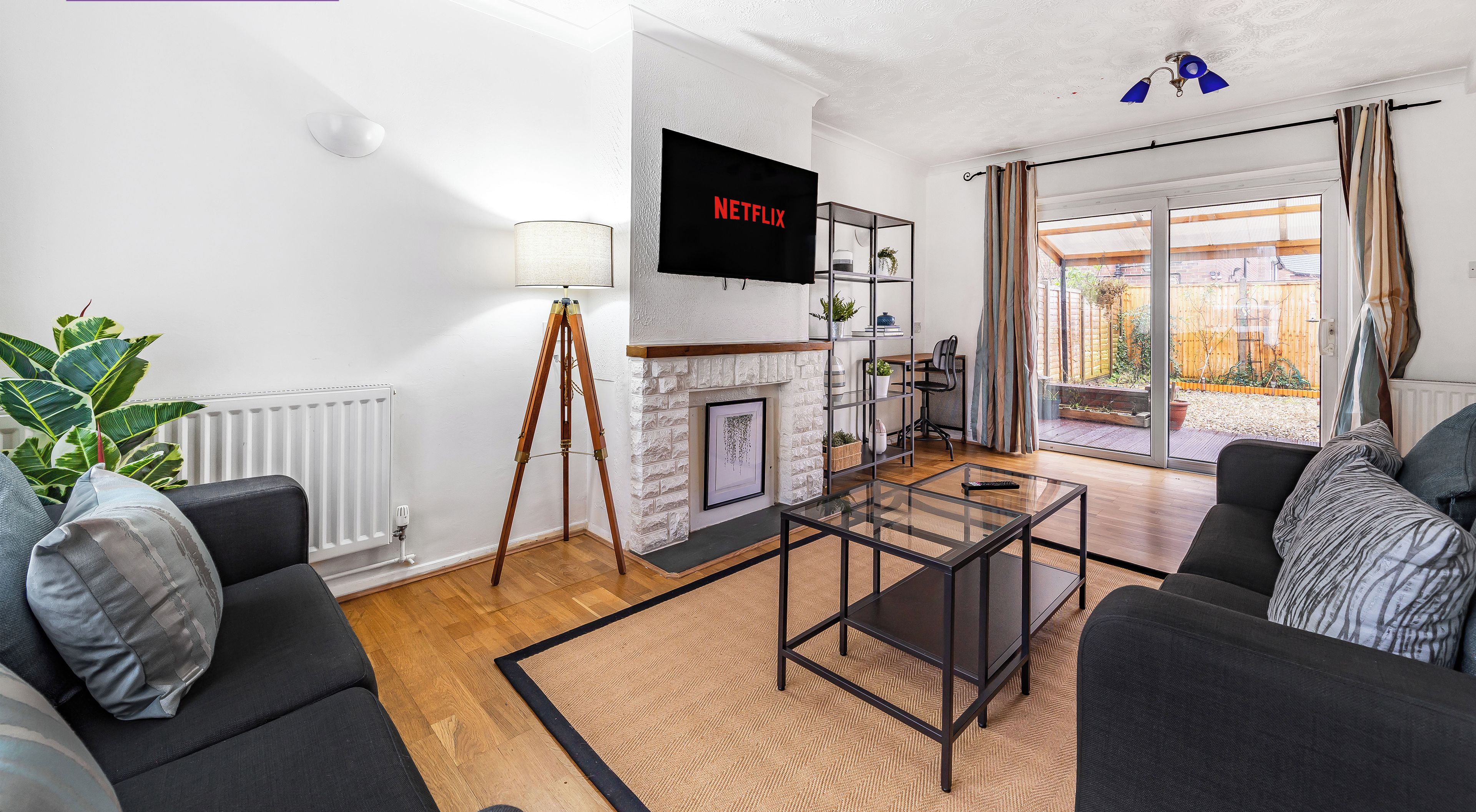 A modern living room with a fireplace, a television, and a view of the outside.