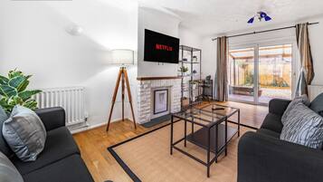 A modern living room with a fireplace, a television, and a view of the outside.