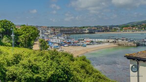 A coastal town with a marina, sandy beach, and buildings along the waterfront. - Pebbles - The Haven, Swanage (Swanage)