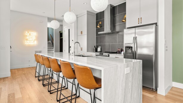 A modern kitchen with a central island, stainless steel appliances, and pendant lighting. - 3-Level Lux Home! Rooftop! Firepit! 6 min to DT! (Nashville)