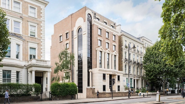 Un edificio de varios pisos con una entrada central destacada, amplias ventanas y un estilo arquitectónico clásico.