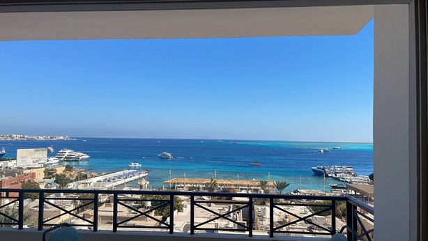 A balcony with a view of the sea, boats, and a marina. - Sea view  3-bedroom apartment in delightful hurghada , 
 with AC, WiFi (Red Sea Governorate)