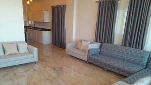A living room with a beige sofa, a grey sofa, and a grey patterned sofa. - Sea view  3-bedroom apartment in delightful hurghada , 
 with AC, WiFi (Red Sea Governorate)