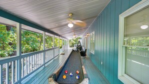En smal, avskild korridor med ett shuffleboard-bord, träräcken och takfläktar.