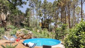 Une piscine extérieure avec des chaises longues et une terrasse en bois.