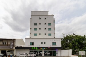Ein mehrstöckiges Gebäude mit einem geschäftlichen Erdgeschoss, das ein Restaurant namens 'SAL Infinity Plus' beherbergt.