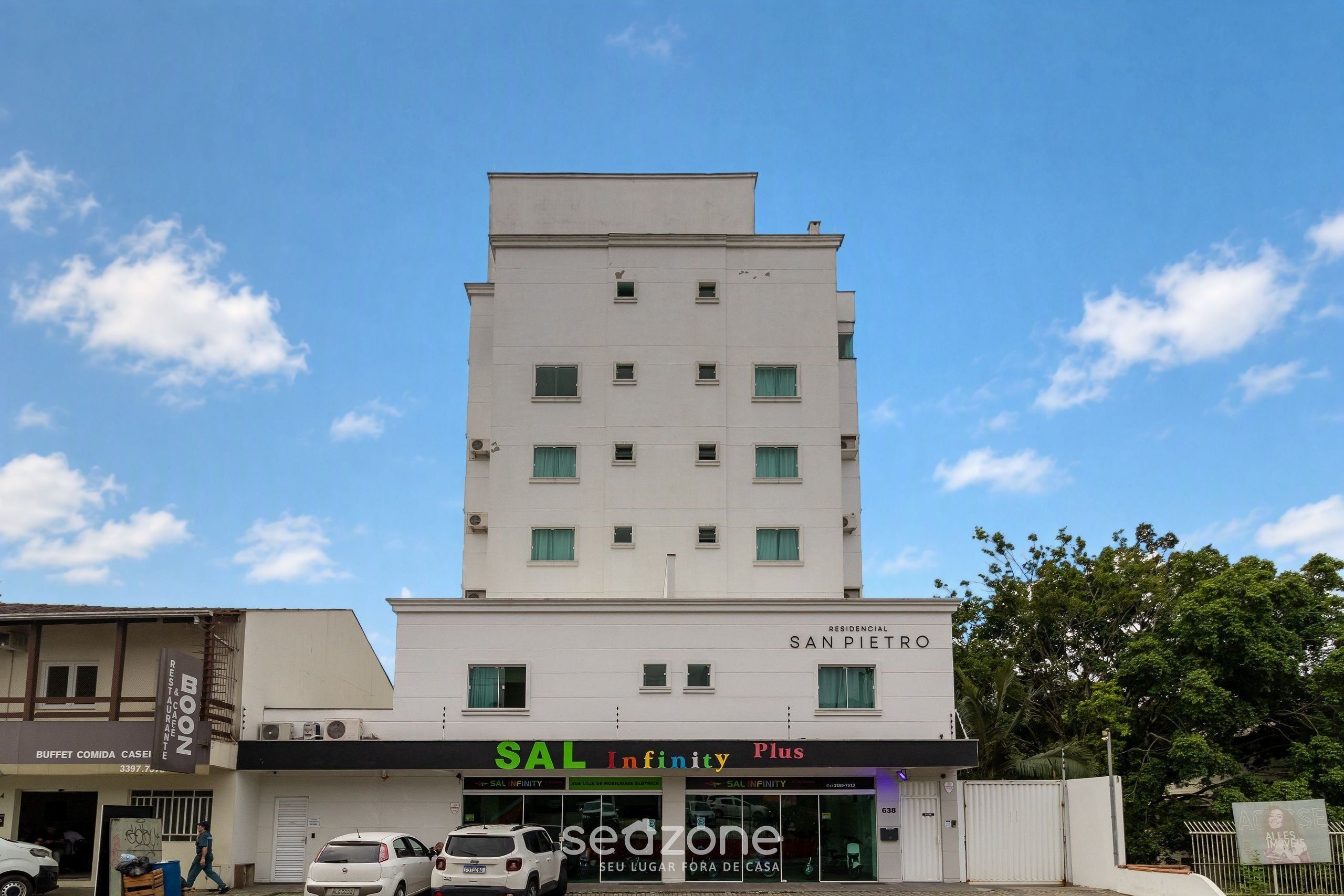 A multi-story building with a sign for 'RESIDENCIAL SAN PIETRO' and a storefront for 'SAL INFINITY Plus'.