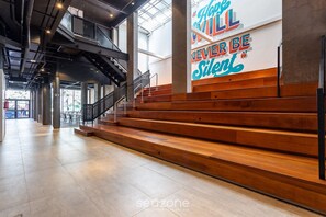 A spacious interior with a staircase, a large wall with motivational text, and a modern design. - TCO Apto Centro Histórico Porto Alegre (Porto Alegre)