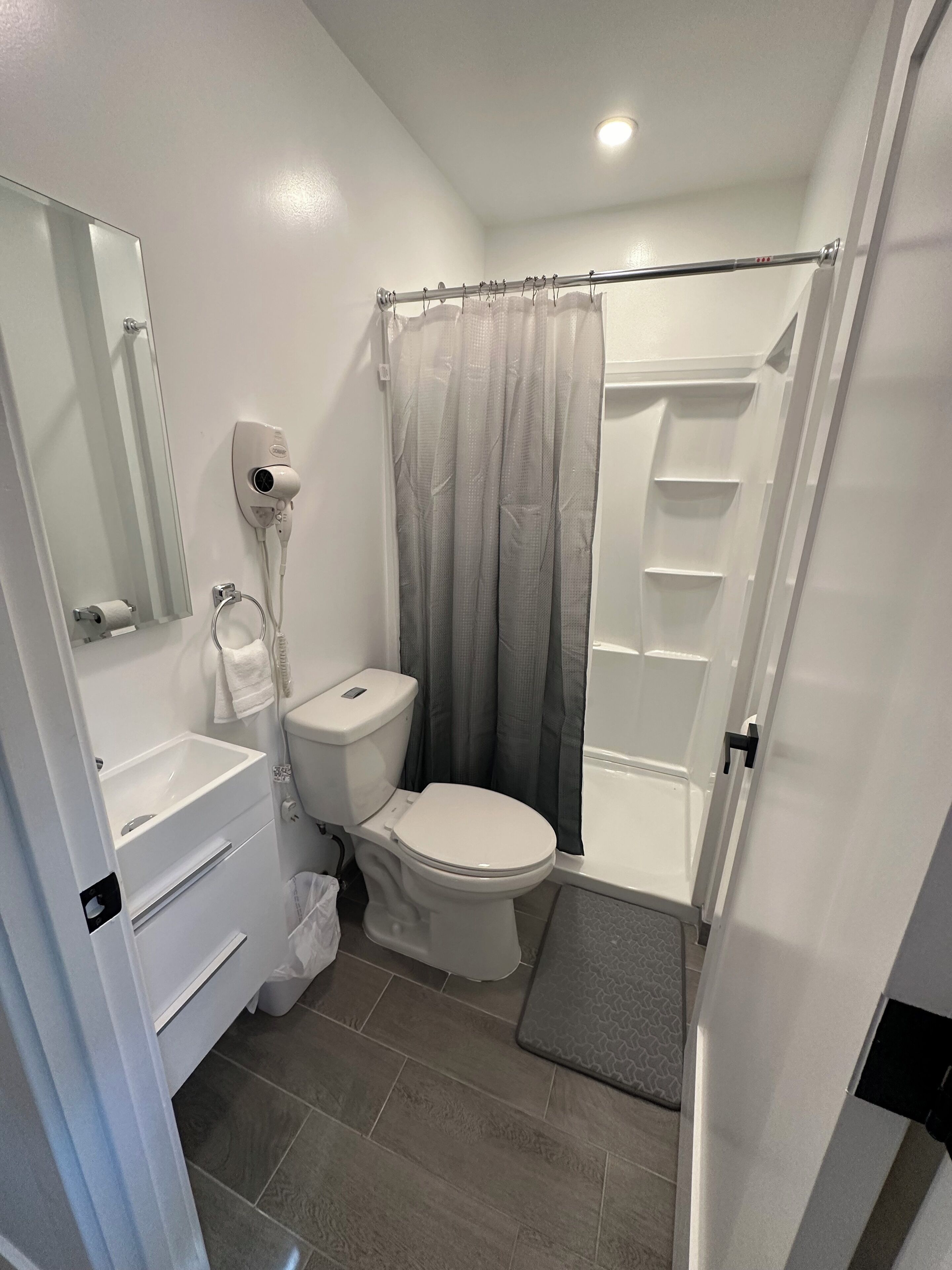 A bathroom with a toilet, sink, and shower.
