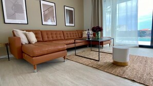 Een moderne woonkamer met een hoekbank, een salontafel en een groot raam met uitzicht.
