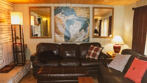 Ein gemütliches Wohnzimmer mit einer Ledersofa, einem Couchtisch und einer großen Weltkarte an der Wand.