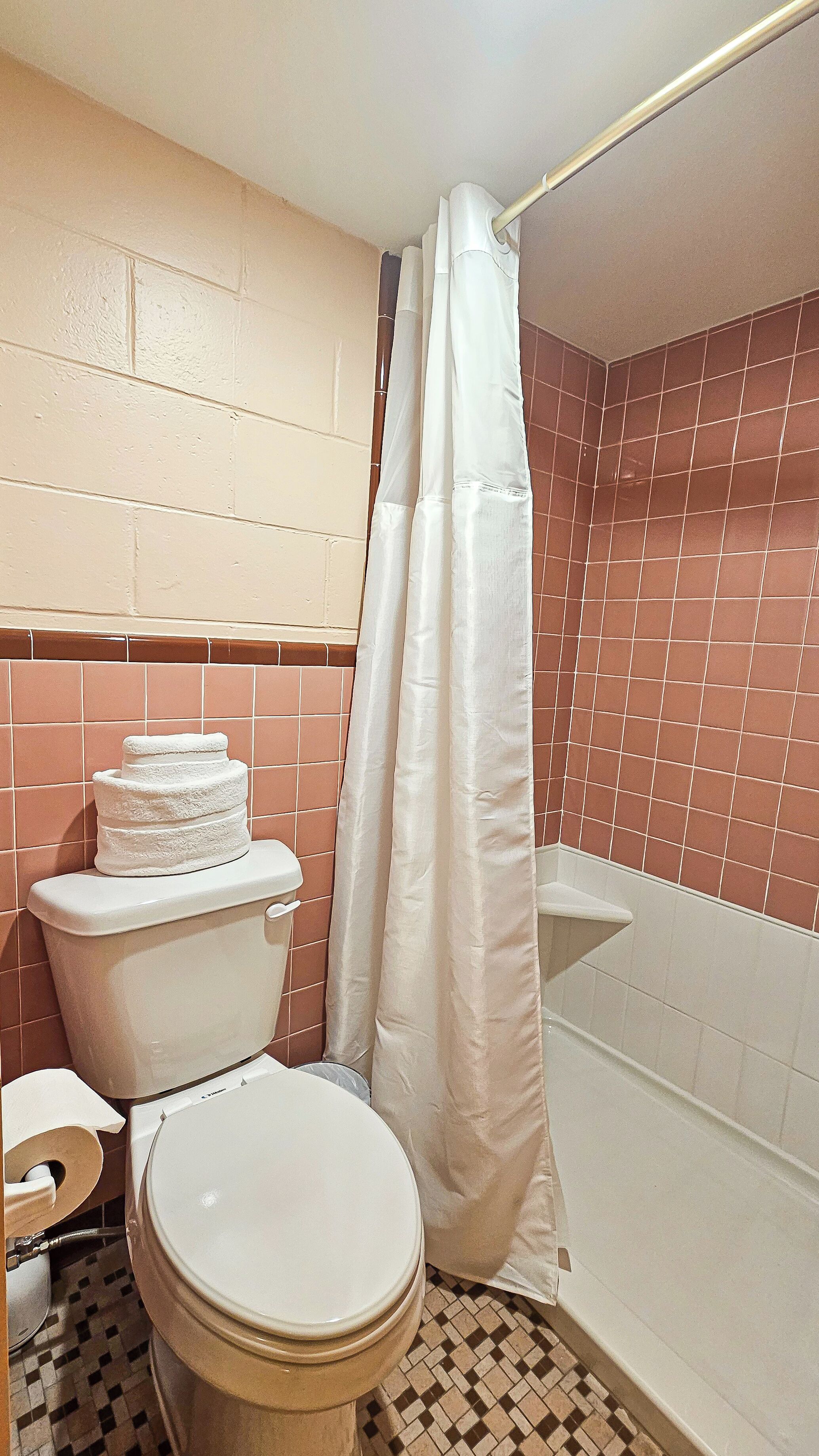 A bathroom with a toilet, a sink, and a shower area.