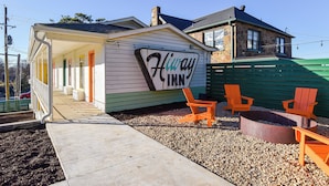 A small, single-story building with a sign reading "Hiway Inn." It features a covered porch with a bench and two orange chairs. - Mid-Century Themed Hotel Room in Fayetteville, AR - The Clementine on College #1 (Fayetteville)