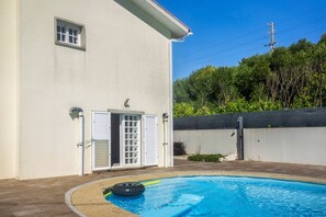 A swimming pool with a white house in the background. - Holiday Home 'Casa Dona Lola' with Sea View, Private Pool and Wi-Fi (Moledo)