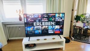A television on a white stand displaying various streaming services. - 2 bedrooms in the heart of city center (Luxembourg City)