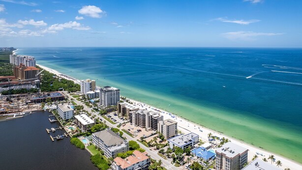 An aerial view of a coastal city with a marina, beachfront hotels, and clear blue waters. - Villa Del Mare Beach 4 Ensuite Retreat + Heated Pool – Special Offer! (Naples)