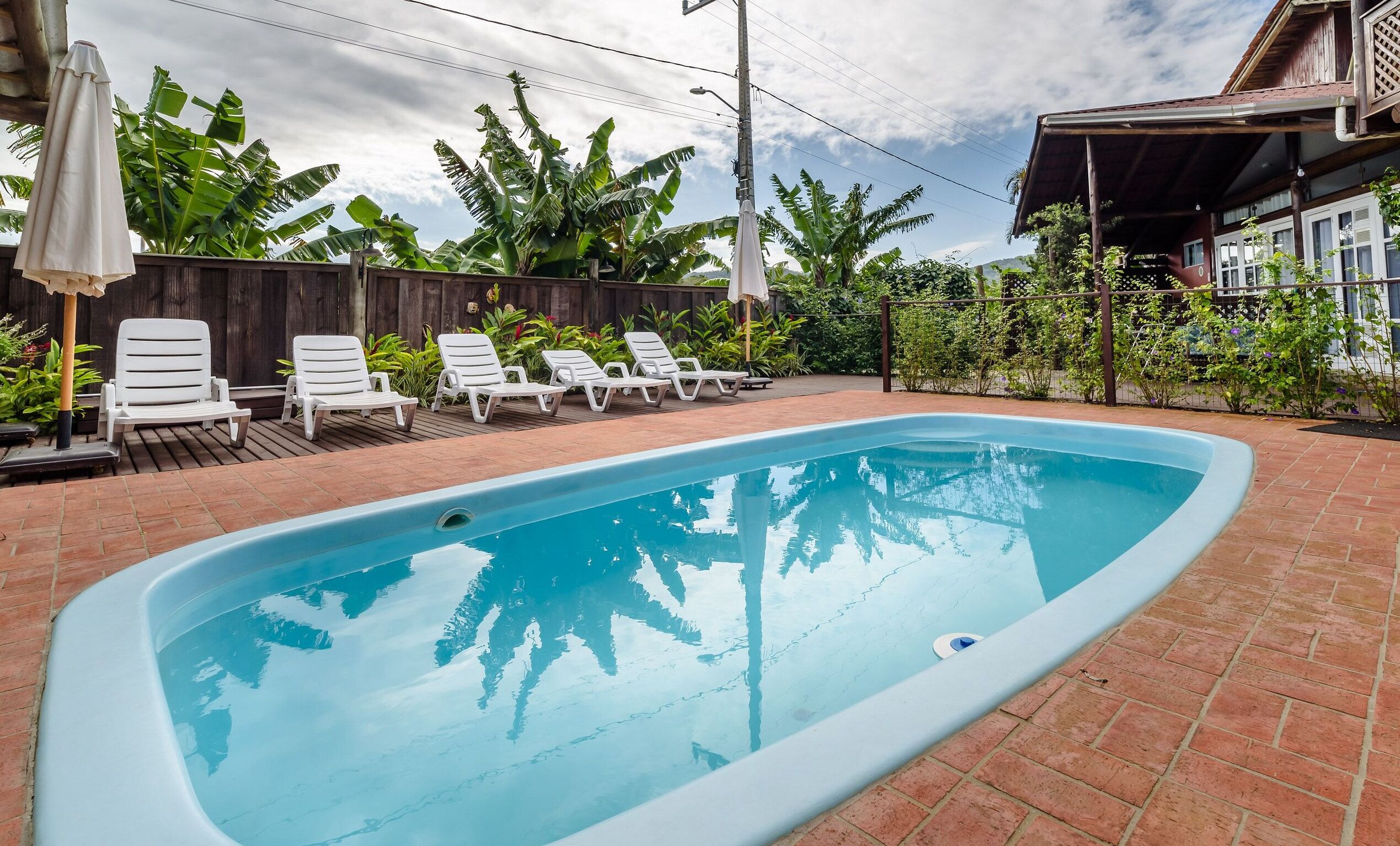 室外游泳池，池畔遮阳伞，日光浴躺椅