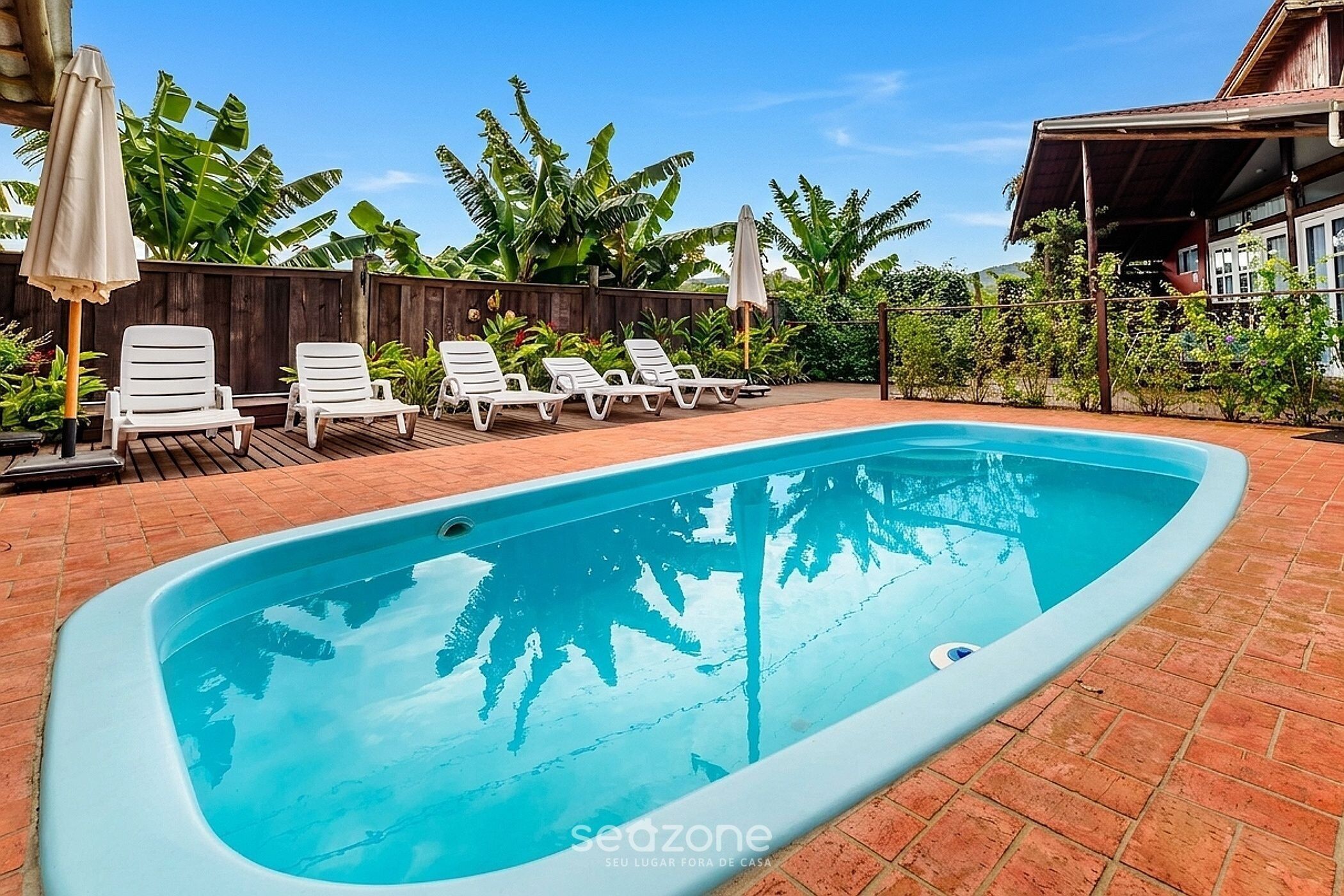 Una piscina al aire libre, sombrillas, tumbonas
