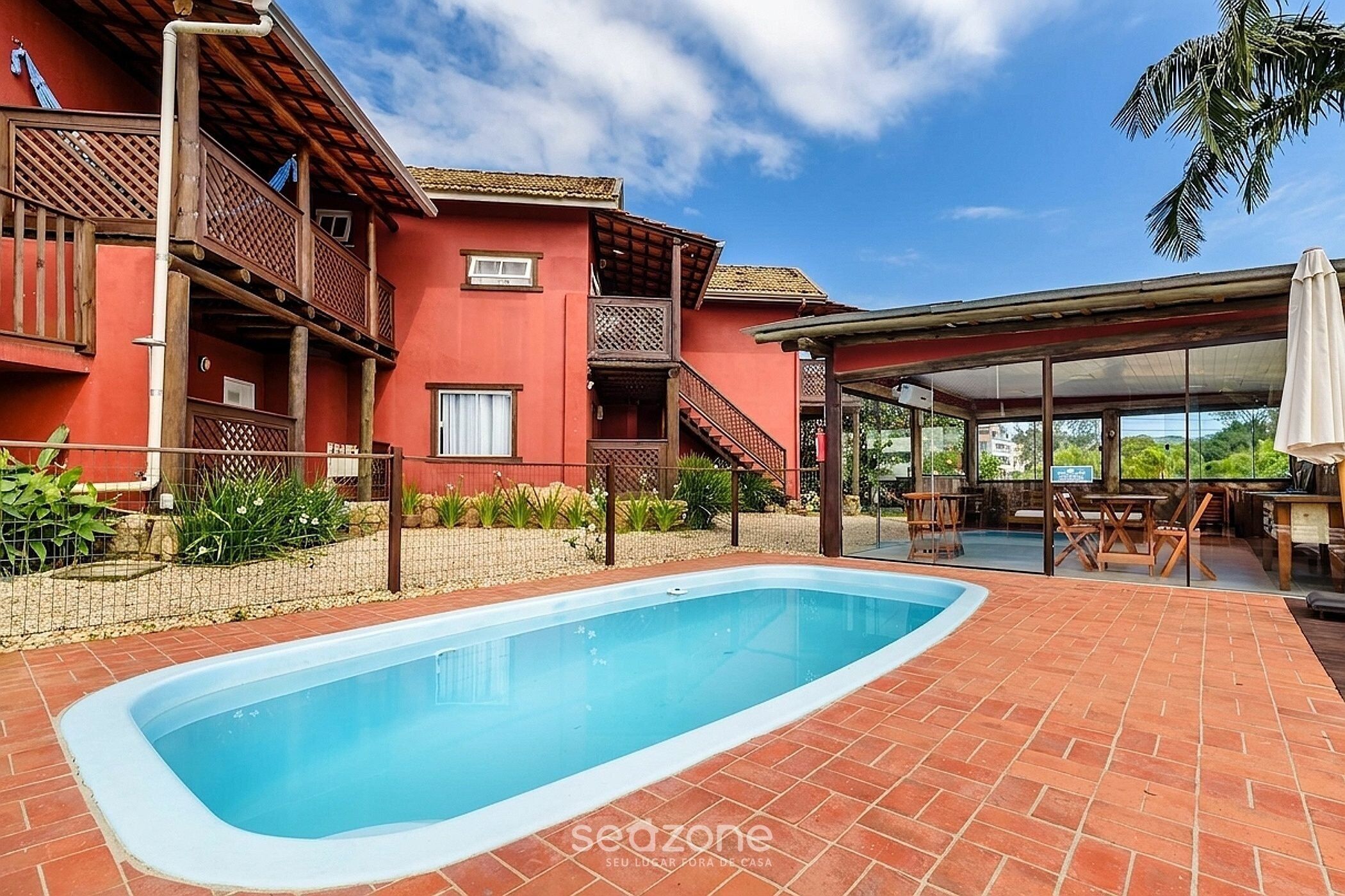 Una piscina al aire libre, sombrillas, sillones reclinables de piscina