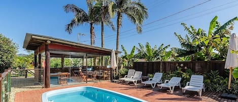Departamento básico | Alberca | Alberca al aire libre, sombrillas en la alberca y camastros