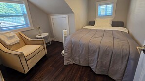 A bedroom with a bed, a chair, a small table, a heater, and a door. - Centrally located 2 bedroom 1.5 bathroom, 15 mins to DT Vancouver (Vancouver)