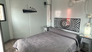 A bedroom with a bed, a wall-mounted air conditioner, a decorative wall piece, and a window. - Casa Faro 5 minutes from the beach  (Barra de Navidad)