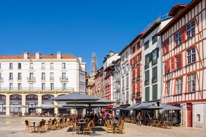 Une rue européenne bordée de terrasses et de bâtiments traditionnels.