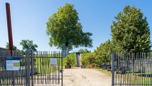 A gated entrance with a pathway leading to a building, surrounded by trees and a clear sky. - Studio Apartment 'Charmant Studio Centre Bayonne' (Bayonne)