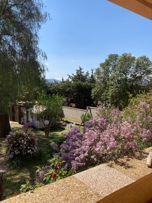 A garden with a variety of plants and trees, a wooden deck, and a view of the surrounding landscape. - Provence getaway, pool, garden, beach 10 minutes away (Puget-sur-Argens)