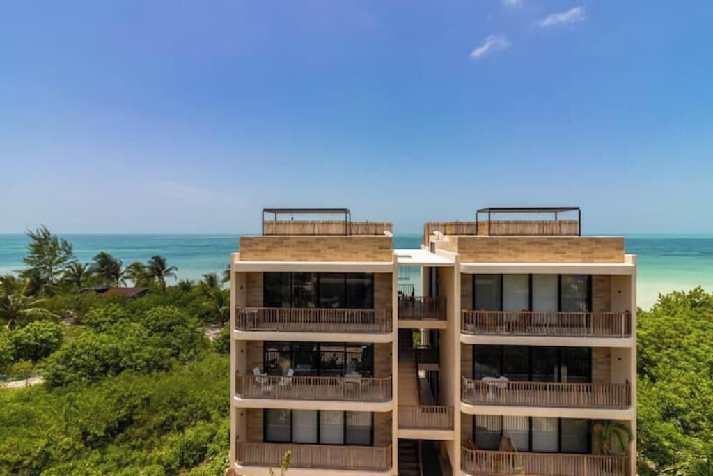 Un hotel modern amb balcons que donen a una platja.