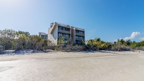 A beachfront hotel with a modern design, featuring multiple floors and balconies.