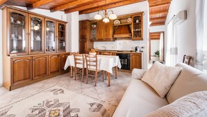 Un interior de madera con una mesa de comedor, sillas, un sofá y una zona de cocina.
