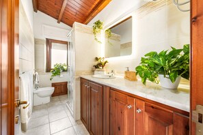 Un baño con muebles de madera, un lavabo, un bidé y un espejo.